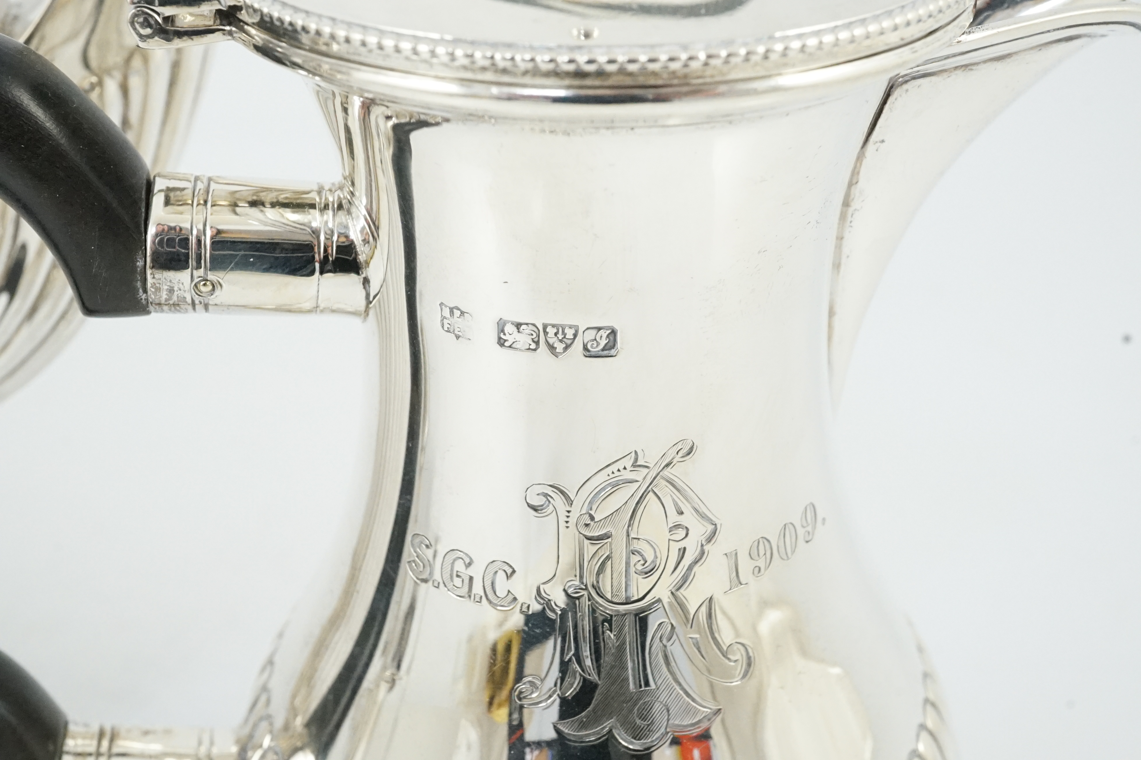 An Edwardian demi-fluted silver tea kettle on stand with burner, with matching pedestal coffee pot and hot water pot, by Barker Brothers
